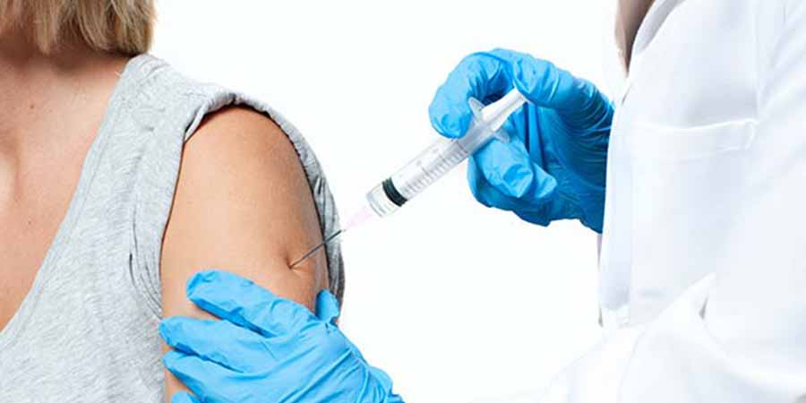 Patient receives a flu shot from her doctor.