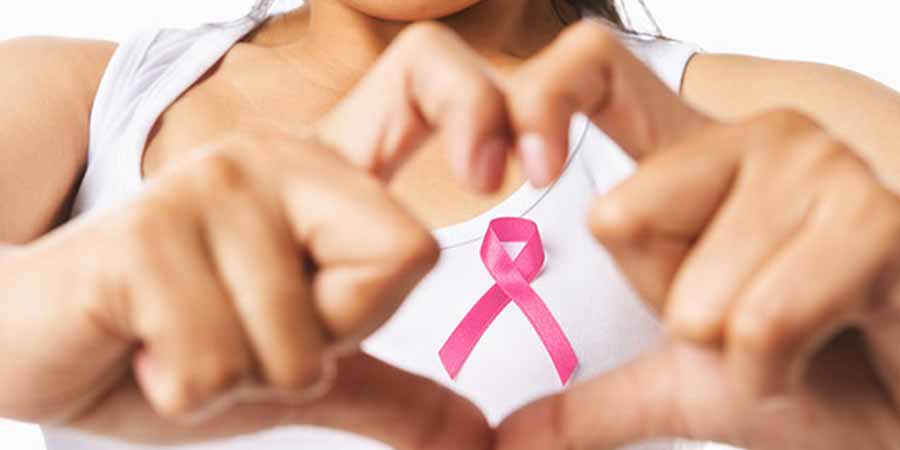 Two hands framing a pink ribbon.